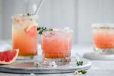 two glasses filled with watermelon and garnished with herbs on a tray