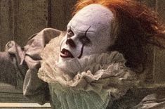 a creepy clown with red hair and makeup