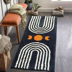 a rug with an orange and white design on it in a living room next to a chair