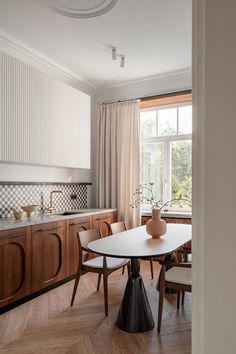 a dining room table and chairs in front of a window