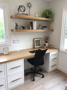 a home office with white cabinets and wooden shelves, along with a black chair in front of the desk