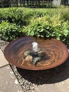 a bird bath sitting in the middle of a garden