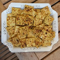 a white plate topped with crackers on top of a wooden table