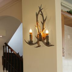 two deer antlers mounted to the side of a wall next to a stair case