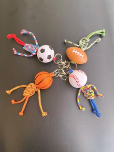 several sports themed key chains are laying on a table with balls and ropes attached to them