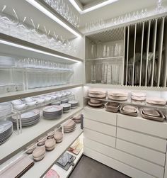 there are many plates on the shelves in this kitchen