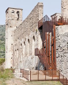 an old stone building with stairs leading up to it