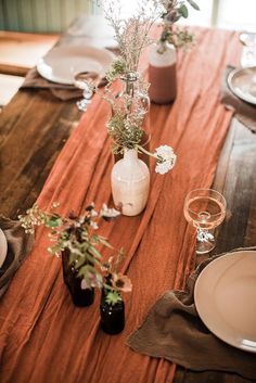 the table is set with vases and plates