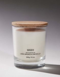 a white candle with a wooden lid sitting on a table