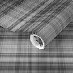 a black and white plaid wallpaper with a rolled up roll on the floor next to it