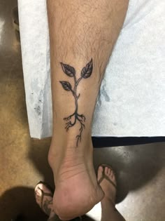 a person with a tattoo on their foot that has a plant growing out of it