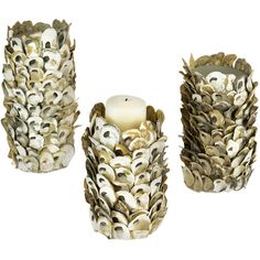 three vases made out of shells with a candle in the middle