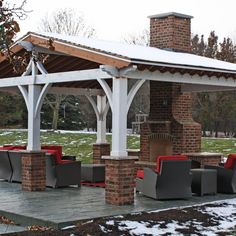 a gazebo with red chairs and tables under it in the middle of a snow covered field