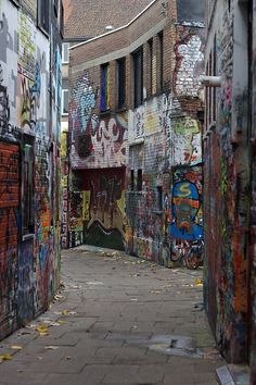 an alley with graffiti all over the walls