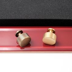 two knobs on the side of a red shelf