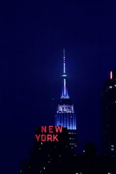 the empire building lit up in blue and white