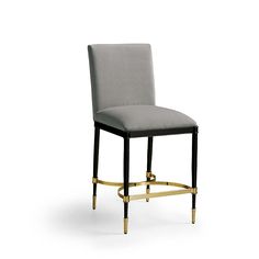 an upholstered chair with black legs and gold trimmings, against a white background