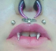 a woman's nose with fake teeth and piercings on top of her lip