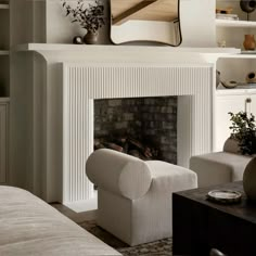 a living room filled with furniture and a fire place covered in a mirror above a fireplace