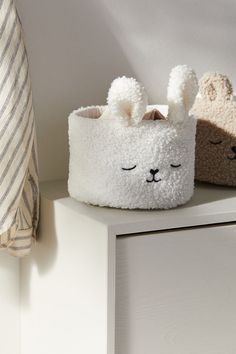 two stuffed animals sitting on top of a white shelf