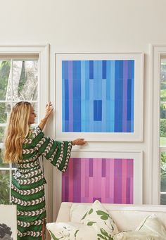 a woman is painting on the wall in her living room