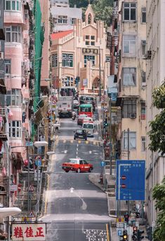 an empty city street with cars parked on both sides and buildings in the back ground