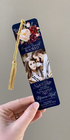 a hand holding up a blue and white photo bookmark with a tassel hanging from it