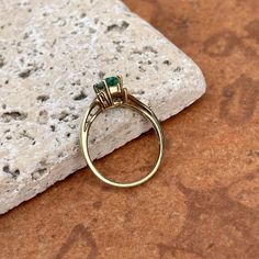 Estate/ vintage polished 10KT yellow gold ring with center, lab-created emerald + surrounding white diamonds. Timeless gold ring with a beautiful, vibrant green emerald! Size 7.25 Can be resized for an additional fee Weight: 1.8g (2) 1 pt genuine, white diamonds; SI clarity; H color Approx. 6mm x 4mm lab-created, green, rectangle center emerald Excellent estate condition Elegant 14k Stamped Emerald Ring, Classic Gold Emerald Ring With Halo Setting, Classic Brilliant Cut May Birthstone Ring, 14k Gold Green Diamond Princess Cut Ring, Gold Emerald Ring With Brilliant Cut, Princess Cut Green Diamond Ring In 14k Gold, Green Princess Cut Diamond Ring In 14k Gold, Heirloom Emerald Cut Diamond Ring With Birthstone, Heirloom Emerald Cut Birthstone Diamond Ring