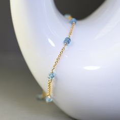 Delicate single strand bracelet created with gemstones in pretty blue color. This bracelet is made with dainty gold filled chain adorned with duos of small, faceted roundels of  London blue topaz. Gems are wrapped with gold filled wire and separated with short sections of dainty,  gold filled chain.  Adjustable from 7.5 to 8.5 inches and it closes with a gold filled lobster claw clasp. Elegant, dainty, trendy, great for layering, bracelet for any occasion. It will make a sweet gift. This style i Blue Birthstone Round Bead Bracelets, Blue Birthstone Bracelets With Round Beads, Blue Beaded Bracelets With Birthstone, Blue Birthstone Beaded Bracelets, Dainty Blue Gemstone Beaded Bracelets, Blue Dainty Gemstone Beaded Bracelet, Dainty Blue Gemstone Bracelets, Blue Aquamarine Gemstone Bracelets, Blue Dainty Birthstone Bracelets