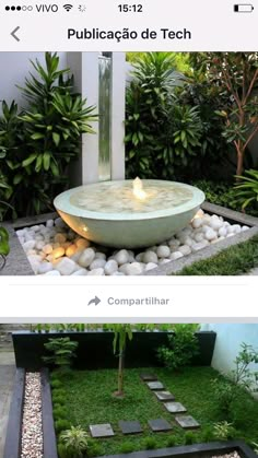 an outdoor fountain in the middle of a garden with rocks and stones around it, surrounded by greenery