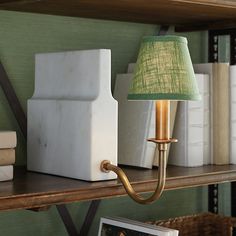 a lamp that is on top of a book shelf next to books and a box