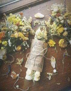 dried flowers and an old piece of paper are on the table next to each other