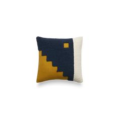 a blue and yellow pillow on a white background with an orange square in the middle