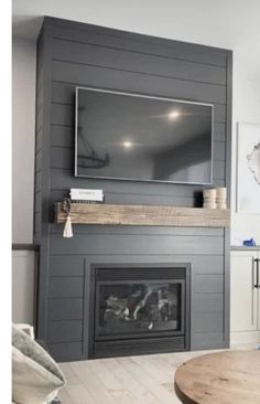 a living room filled with furniture and a flat screen tv mounted on the wall above a fire place