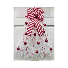 a christmas tree door hanger with red and white ornaments on it's side