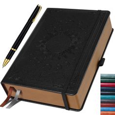 a book with a pen on top of it and colored pencils next to it