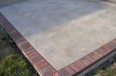 an empty concrete patio in the middle of a yard