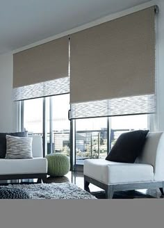 a living room with white couches and brown blinds