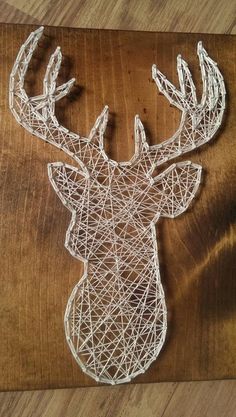 a string sculpture of a deer's head on a wooden surface