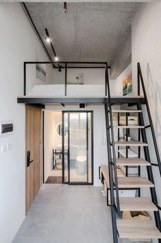 the stairs lead up to the bedroom and bathroom in this modern loft style home, which also has an open floor plan