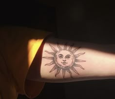 a person with a sun tattoo on their arm