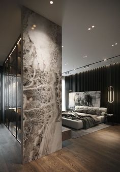 a bedroom with a large marble wall next to a bed in a room that has wooden floors