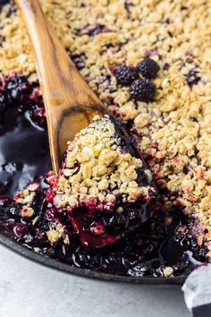 blueberry crumble topping in a skillet with a wooden spoon