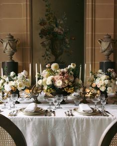 the table is set with flowers and candles