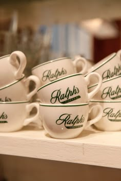 coffee cups are lined up on a shelf in a store display case, with the name robin's relish written on them