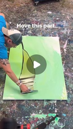 a man is painting on the ground with paint