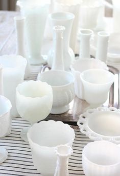 a table topped with white dishes and cups