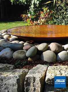 there is a water feature in the middle of some rocks and gravel with a blue sticker on it