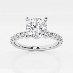 an engagement ring with a cushion cut diamond in the center and pave set shoulders