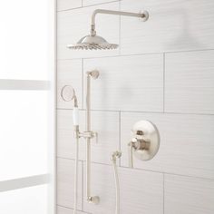 the shower head and hand shower faucet are shown in this white tiled bathroom